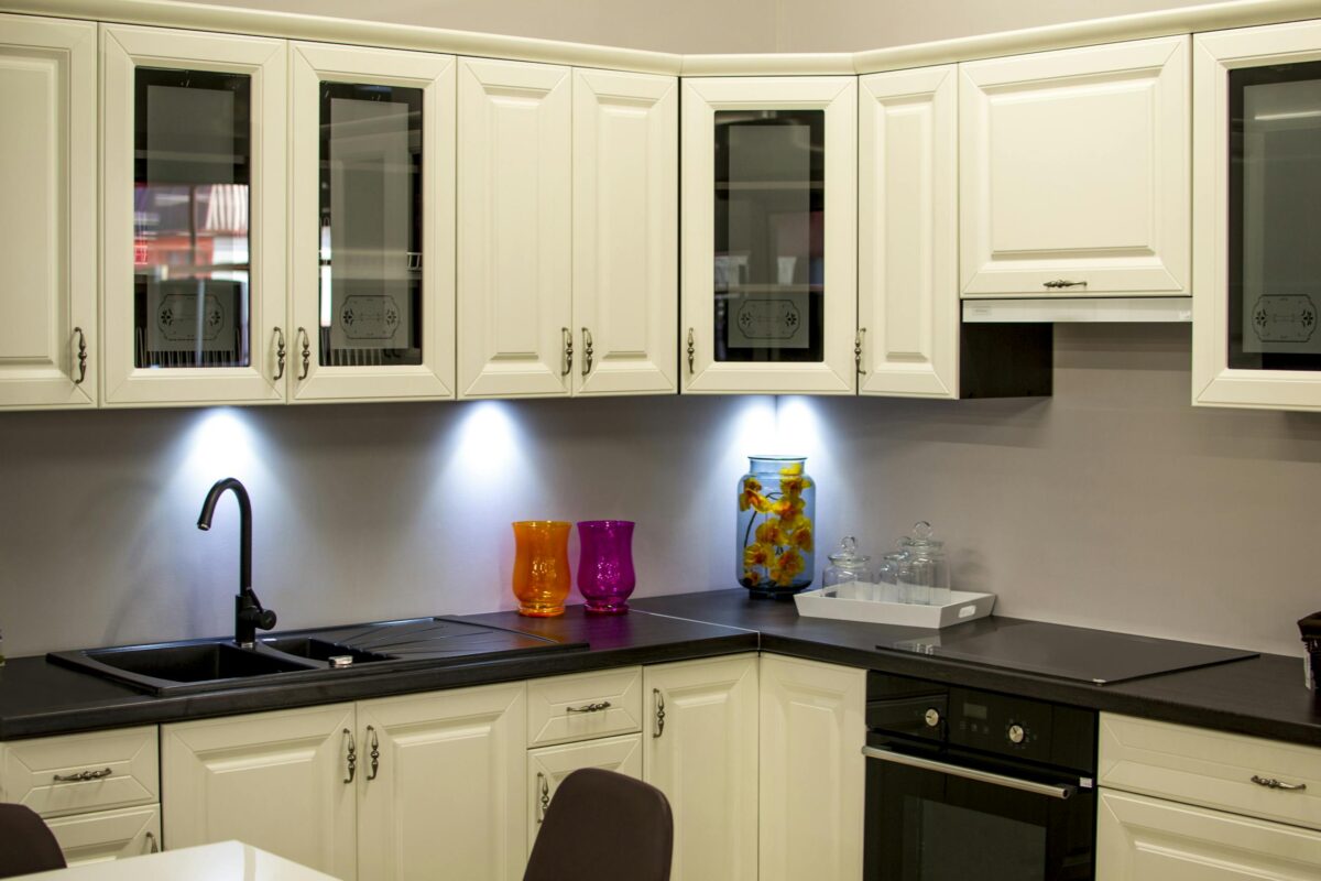 A stylish modern kitchen and dining décor with white cabinets cabinets and colorful decor pieces.