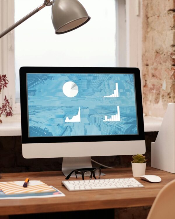 Clean and modern home office setup with computer, lamp, and decor. Ideal for productivity in a contemporary workspace.