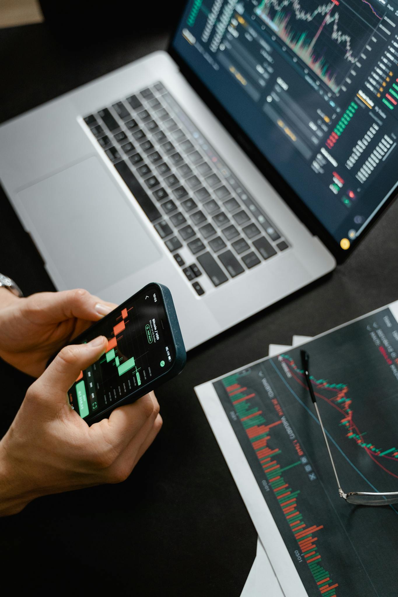 Ecomeboss – Home Décor & Lifestyle Inspiration Hands holding phone with financial graph, laptop in view.