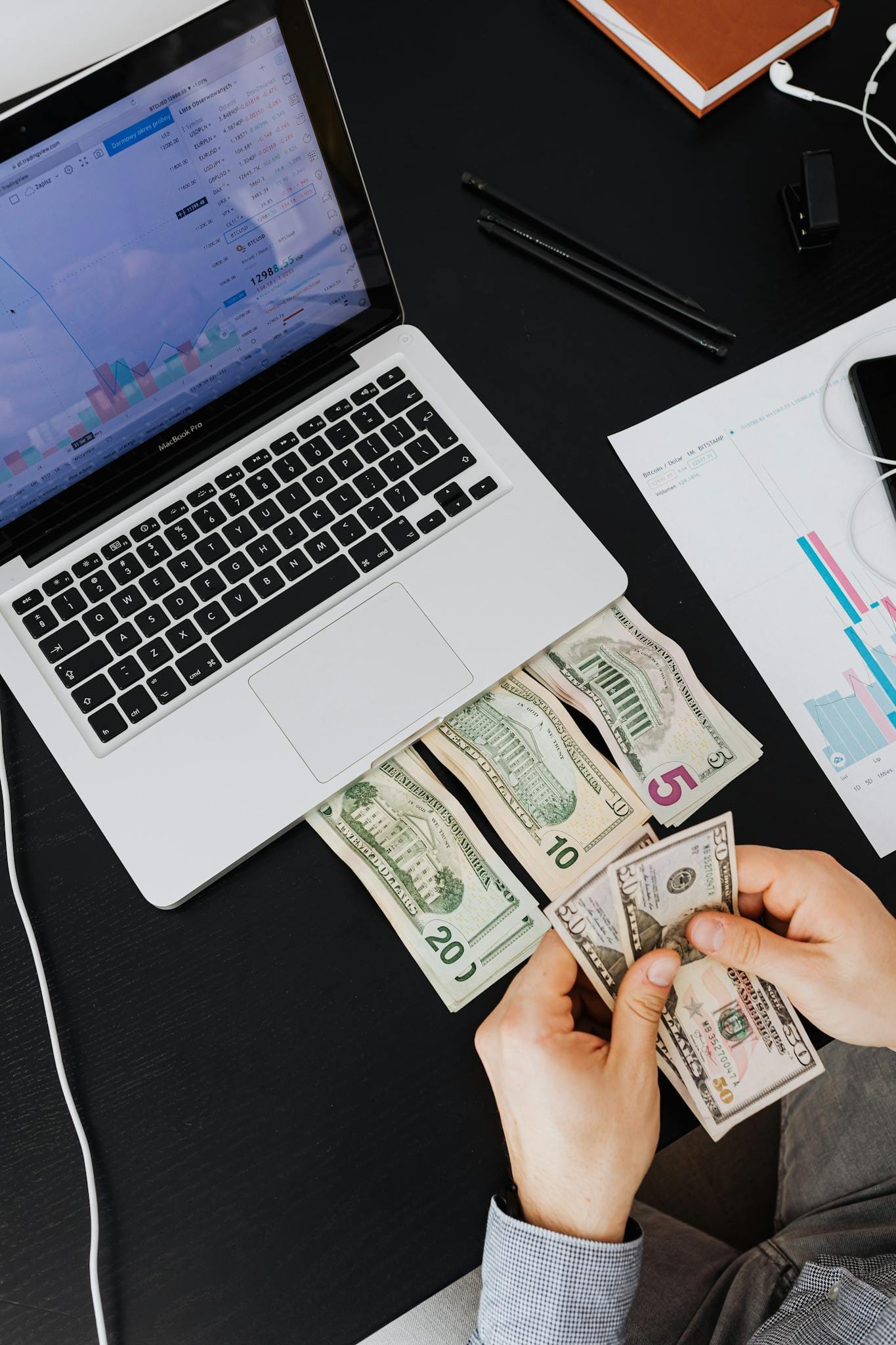 person counting cash with laptop on desk – Services