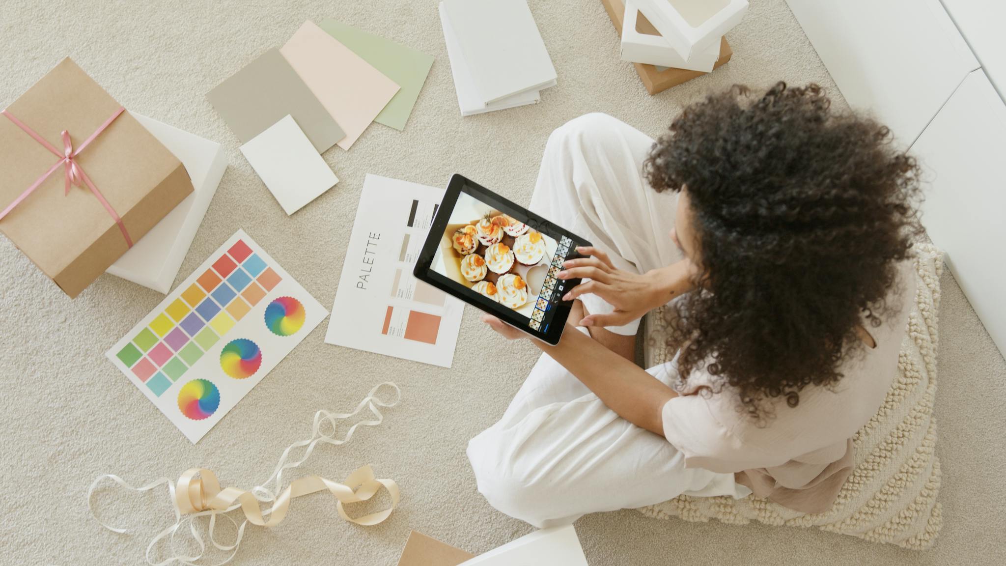 woman using tablet surrounded by design tools – Services